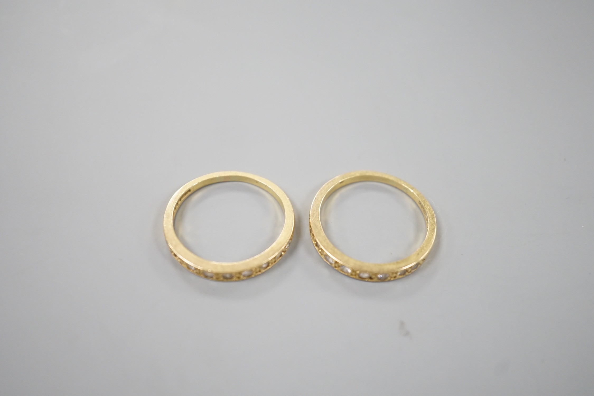A modern pair of 18ct gold and diamond set half eternity rings, size P, gross weight 5.9 grams.